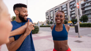 Fitness coach and client walking together outdoors — walking program coaching low-intensity volume protocol