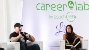 Physique coach in conversation with athlete after competition — athlete longevity hormone health coaching 2026