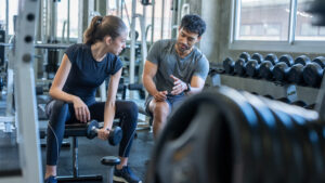 Fitness coach listening attentively to a client during a session — empathy emotional intelligence coaching skill