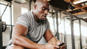 Personal trainer reviewing a client's program and wearable data on a tablet during a coaching session.