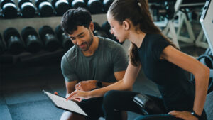 Fitness coach reviewing a client's weekly habit tracker during a check-in session