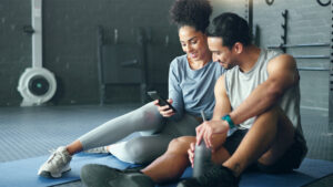 Personal trainer reviewing an AI-generated workout plan on a client's phone during a session.