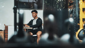 Gym owner reviewing pricing and revenue data at a front desk