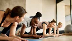 A group fitness class members greeting and talking with each other before class in a gym