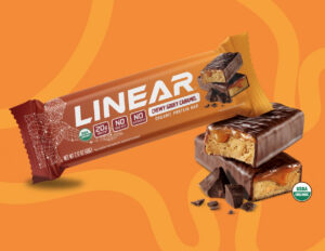 Female athlete and founder holding a clean whey protein bar she developed after an autoimmune health crisis