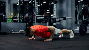 Personal trainer observing a client's trunk and scapular position during a push-up assessment.
