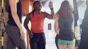 Personal trainer being coached by a mentor on the gym floor at a Crunch Fitness club.